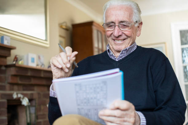 istock Smiling Senior Man Doing Sudoku Puzzle At Home 1298904633