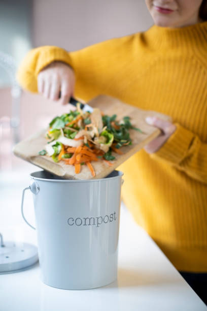 istock Close Up Of Woman Making Compost From Vegetable Leftovers In Kitchen 1298906133
