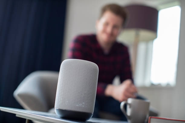 istock Man In  Lounge At Home Asking Digital Assistant Question 1298906536
