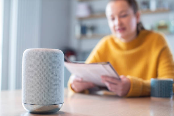 istock Woman Reading Magazine At Home Asking Digital Assistant Question 1298906888