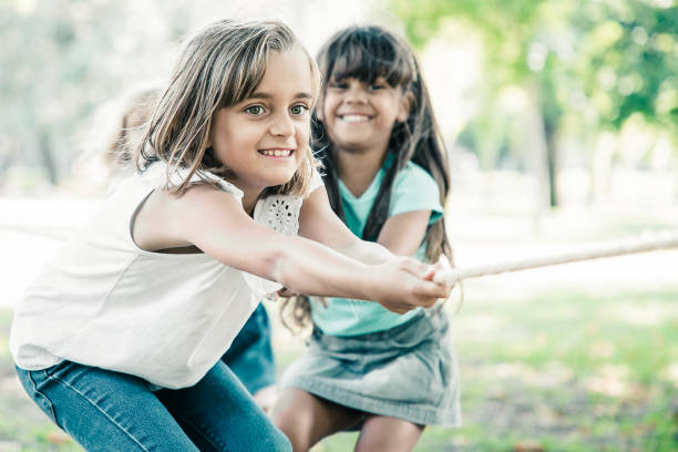 istock Team of happy kids pulling rope 1298908455