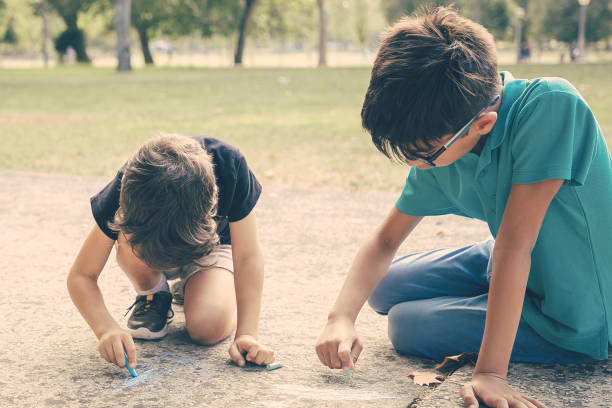 istock Focused boys sitting and drawing 1298910959