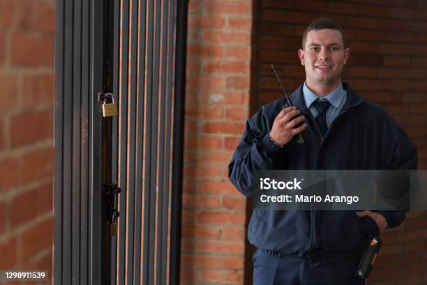 Building Guard Looks At The Camera In A Portrait While Wearing His Uniform And Smiling Stock Photo - Download Image Now