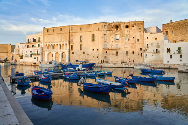 Monopoli old port at sunset with small fishing boats, Puglia Italy Monopoli, Puglia Italy - June 21, 2019 Waterfront with small wooden rowboats. monopoli puglia stock pictures, royalty-free photos & images