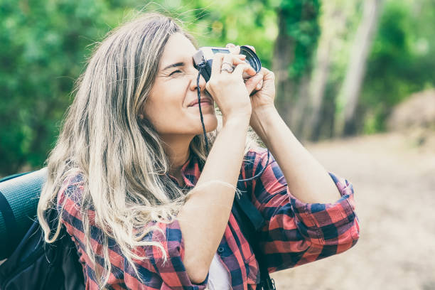 istock Concentrated lady shooting landshate and walking with backpack 1298915269