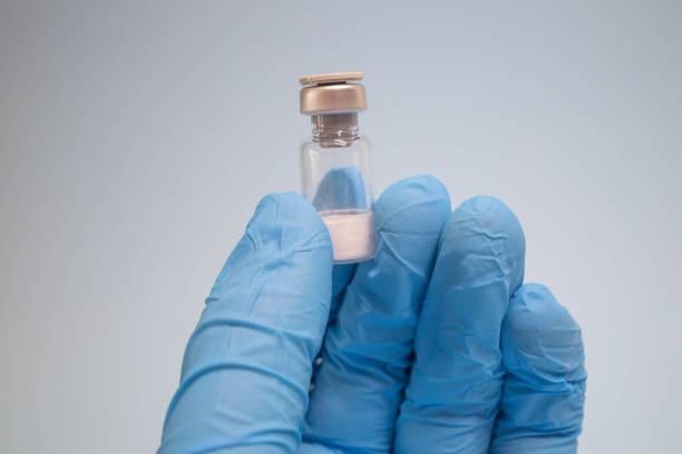 Empty test tube, alchemy, perfumes, two glass bottles with cork stoppers, neutral background, light-colored surface, taller transparent bottle amber liquid, shorter transparent bottle empty interi