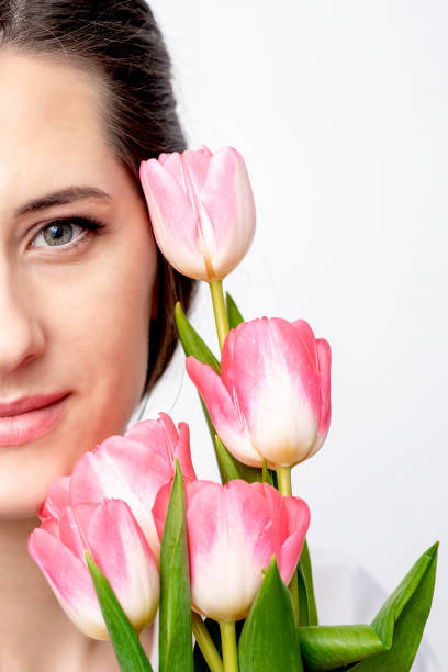 istock Young woman with pink tulips 1298916138