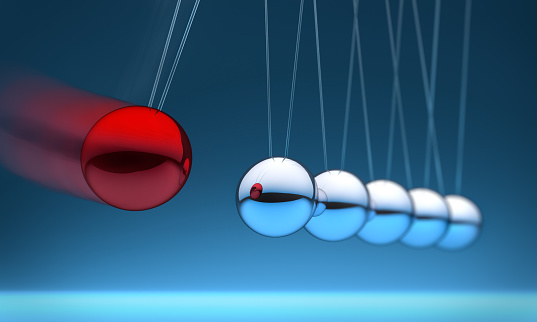 Newtons cradle with six silver and one red metal balls on white background.