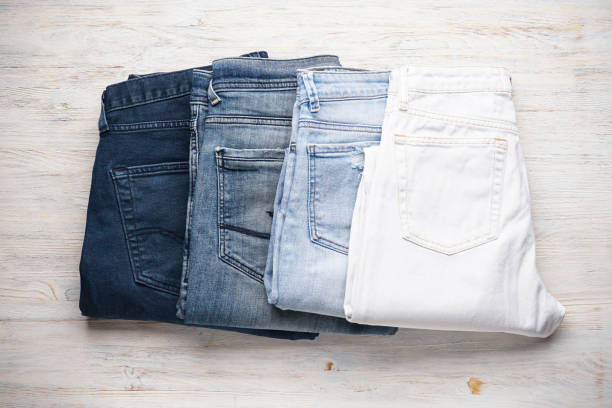istock Jeans stacked on a wooden background, top view. 1298920191