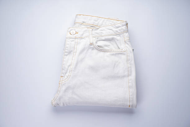 istock White jeans stacked on a gray background, top view. 1298920367
