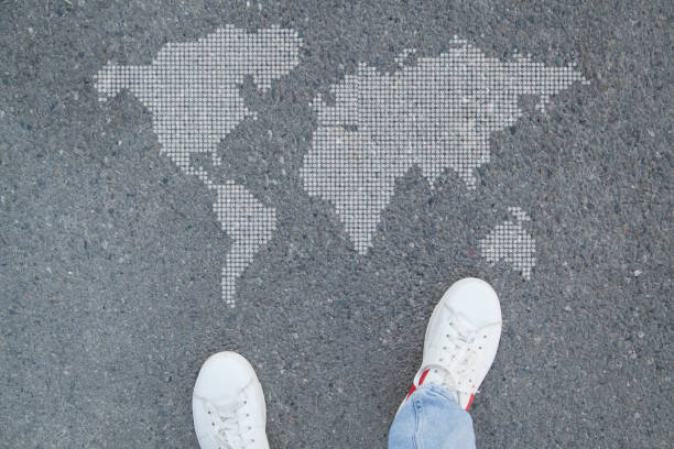 istock Man in shoes standing in asphalt and world map. 1298920851