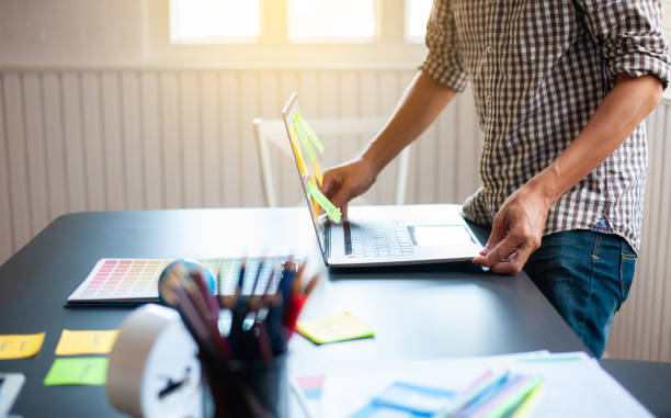 istock A young man working with a laptop on the desk in the office. 1298921522