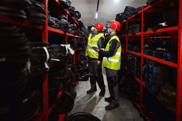istock Two young male male warehouse workers with protective face masks doing stock control by using a digital tablet in a warehouse 1298924552