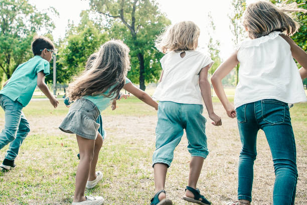 istock Group of active kids having race in park 1298927302