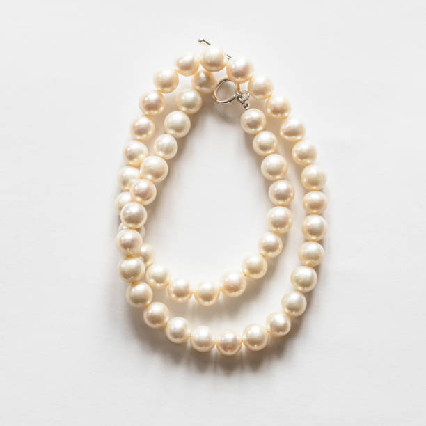 istock folded white pearl necklace on white 1298929176