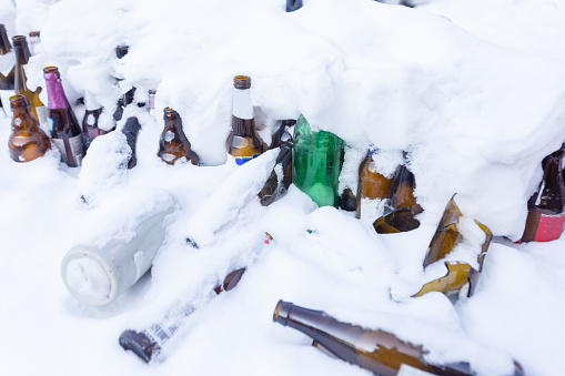 Empty beer bottles in the snow in winter