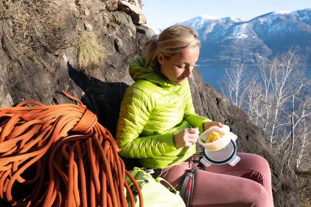 Photo of Rock climber female eating lunch from reusable container