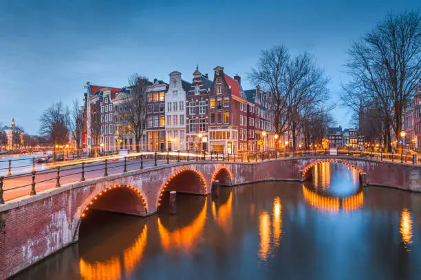 Amsterdam, Netherlands bridges and canals at twilight.