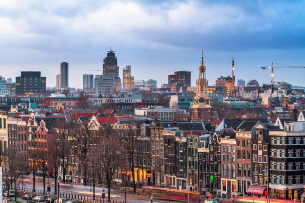 amsterdam, niederländisches historisches stadtbild mit dem modernen stadtteil zuidas in der ferne - amsterdam stock-fotos und bilder