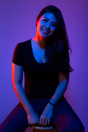 Portrait beauty young asian woman with creative lighting Blue and red or mixed color, colors filters lights with smile face. Attractive Asia girl has long hair Asia lady happy fashion concept