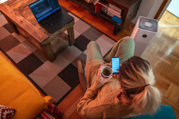 istock Young woman drinking coffee while surfing the net on smartphone 1298934527