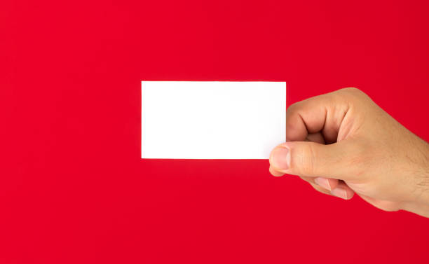 istock Man showing blank white business card isolated on red background 1298934823