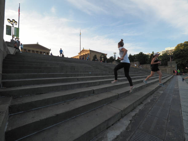 People running up the steps in front of the Philadelphia Museum of Art. Philadelphia, USA - June 11, 2019: People running up the steps in front of the Philadelphia Museum of Art. The steps are also featured in the Rocky movie. benjamin franklin parkway photos stock pictures, royalty-free photos & images