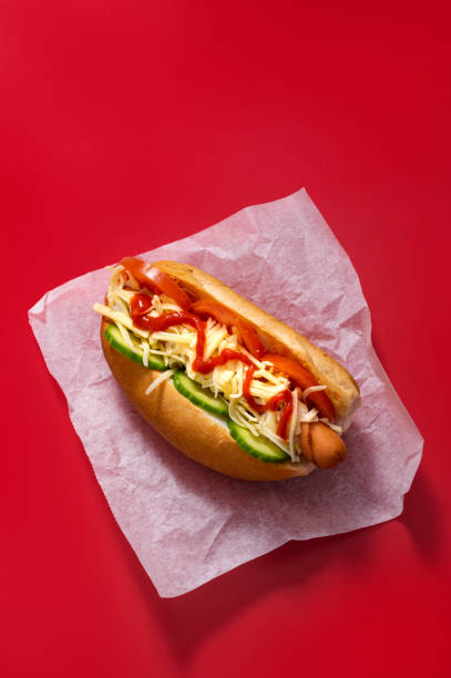 panino hot dog sporco gourmet con vari guarnire su sfondo rosso. opzione sana di fast food. - salsa relish cucumber party foto e immagini stock