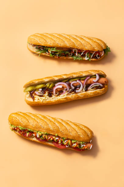 panino hot dog sporco gourmet con vari guarnire su sfondo giallo. opzione sana di fast food. - salsa relish cucumber party foto e immagini stock