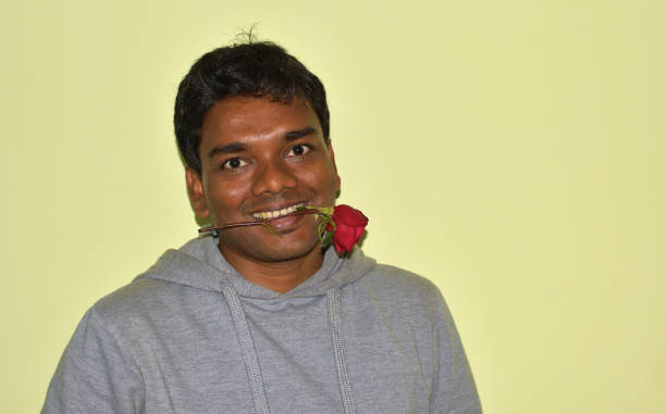 istock indian young man with a red rose in his mouth 1298941543