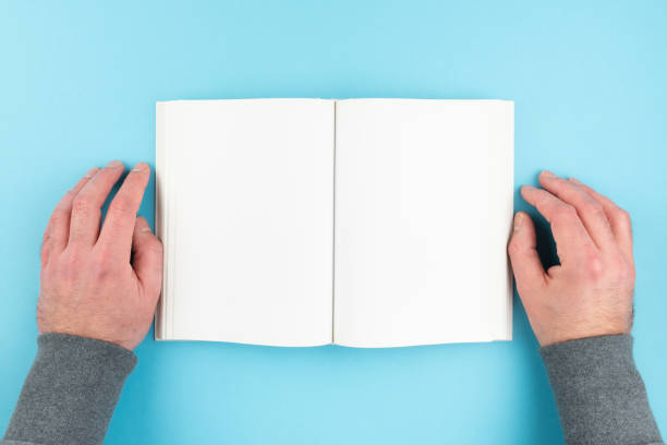 istock overhead view of person reading book with hands resting on both sides 1298943980