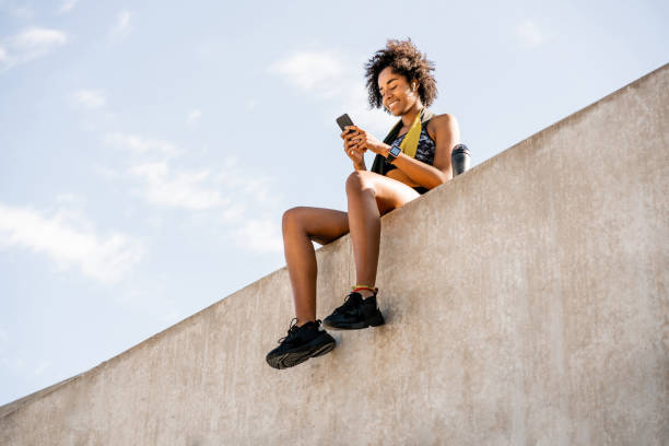 istock Athlete woman using her mobile phone outdoors. 1298944026