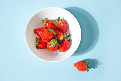 Ripe red strawberries on the blue background. Top view