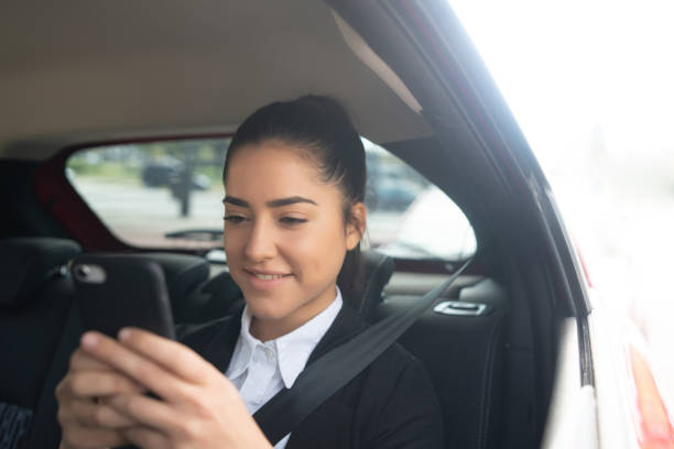 istock Businesswoman using mobile phone in car. 1298945045