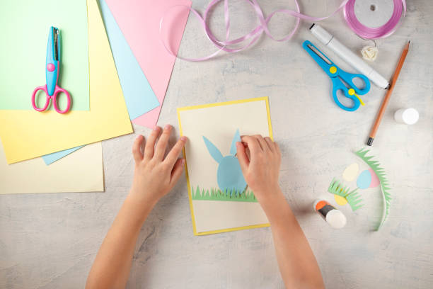 istock DIY and kids creativity. Step by step instruction: how to make card Happy easter. Step3 glue paper ears of rabbit. Childrens handmade Easter craft 1298947280