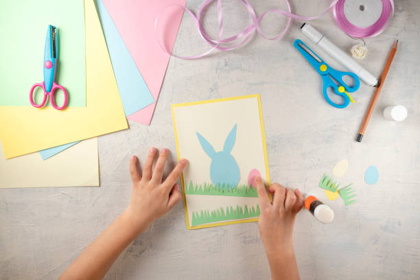 istock DIY and kids creativity. Step by step instruction: how to make card Happy easter. Step4 glue paper eggs and grass. Childrens handmade Easter craft 1298947350