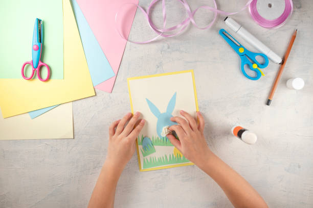 istock DIY and kids creativity. Step by step instruction: how to make card Happy easter. Step5 glue flower instead of rabbit tail. Childrens handmade Easter craft 1298947399