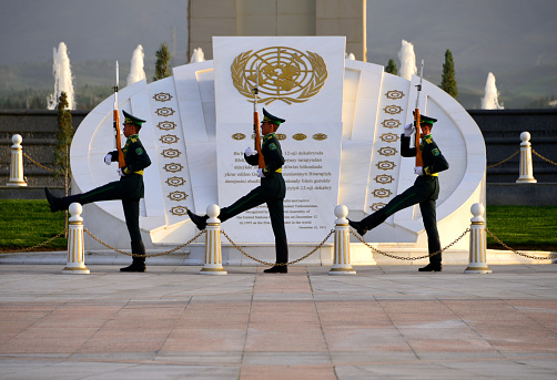 Ashgabat, Turkmenistan: goose stepping soldiers, change of the ceremonial guard at the Monument of Neutrality aka Arch of Neutrality, Neutrality Avenue - UN logo over white marble - Neutrality was enshrined in Turkmen legislation and by the UN with the adoption of the UN General Assembly resolution on Permanent Neutrality of Turkmenistan - soldiers carrying SKS Soviet semi-automatic carbines (gas-operated rifle) - Bitaraplyk arkasy / Bitaraplyk binasy.