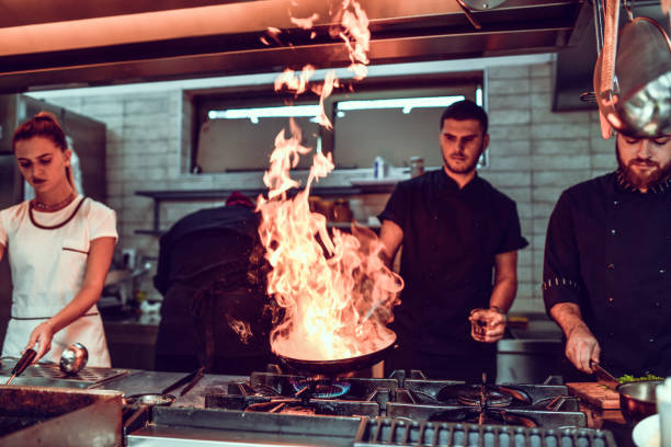 istock Chef Making Flaming Pan Recipe In Restaurant Kitchen 1298948498