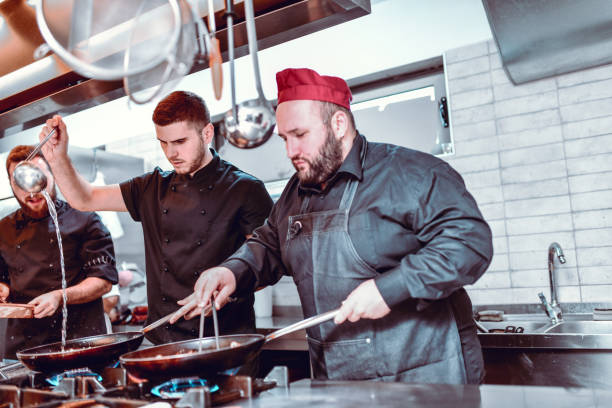 istock Busy Cooks Working In Modern Restaurant Kitchen 1298948583