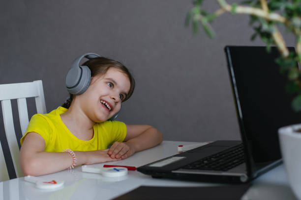 istock Cute Girl Kid Listens To Music Learns a Foreign Language Learns Remotely. 1298950155