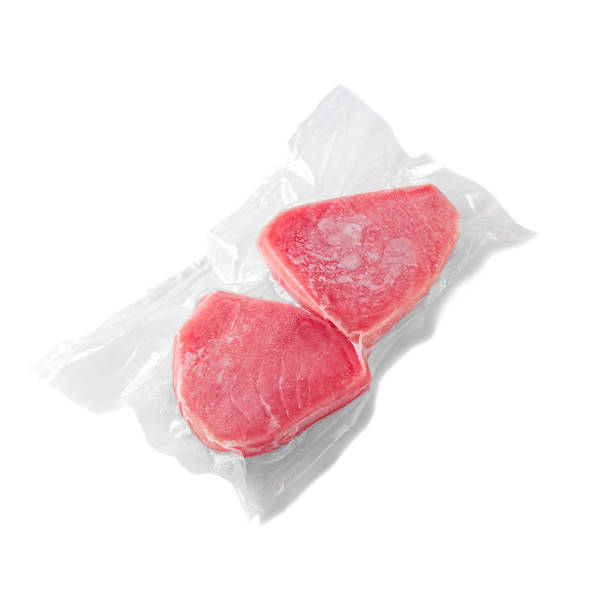 istock Frozen tuna steak. In plastic packaging. White background. Isolated. 1298951934
