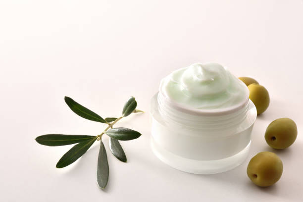 istock Olive moisturizing cream for skin on white table elevated 1298952826