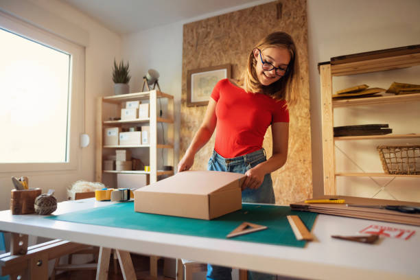 istock Female entrepreneur packaging box for delivery. 1298954487