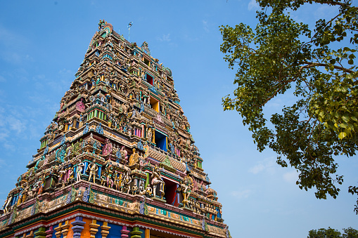 Traditional Hindu temple Kidangamparambu Sree Bhuvaneswari in India in Allapuzha (Allepi) Kerala. Tall building with colorful figures of Indian mythology and gods, flock of live birds. Tourism, travel