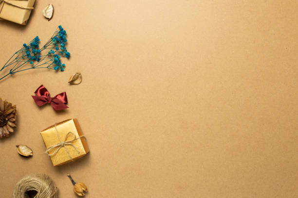 istock Gift box, dry flower, ribbon, string on brown kraft paper background. flat lay, top view, copy space 1298957336