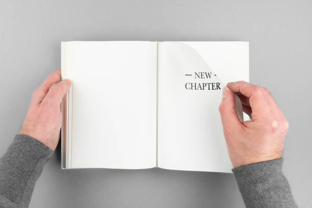 person flipping page of book with text NEW CHAPTER overhead view of person flipping page of book with text NEW CHAPTER new page stock pictures, royalty-free photos & images