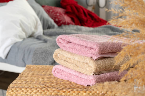 istock Stack of clean towels on wooden table in bedroom 1298957633