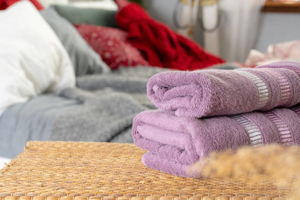 istock Stack of clean towels on wooden table in bedroom 1298958318