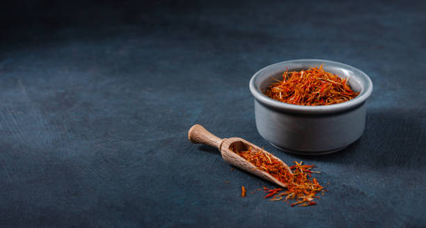 oriental spice saffron in a blue ceramic bowl on a dark table. oriental spice saffron in a blue ceramic bowl on a dark table. Copy space substitute for saffron stock pictures, royalty-free photos & images